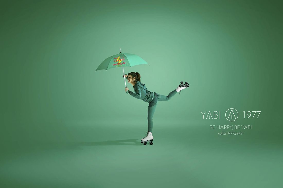YABI 1977 en verde: patinadora con paraguas que dice hoy estoy lleno de energía